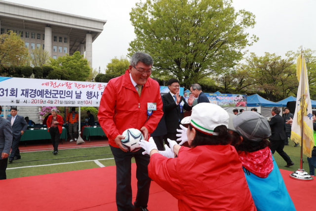 지난 21일 여의도 국회 운동장에서 열린 재경 예천군민의 날 행사에서 김학동 예천군수가 대한민국 축구종합센터 유치를 기원하며 출향인들에게 축구공을 나눠주고 있다. 예천군 제공