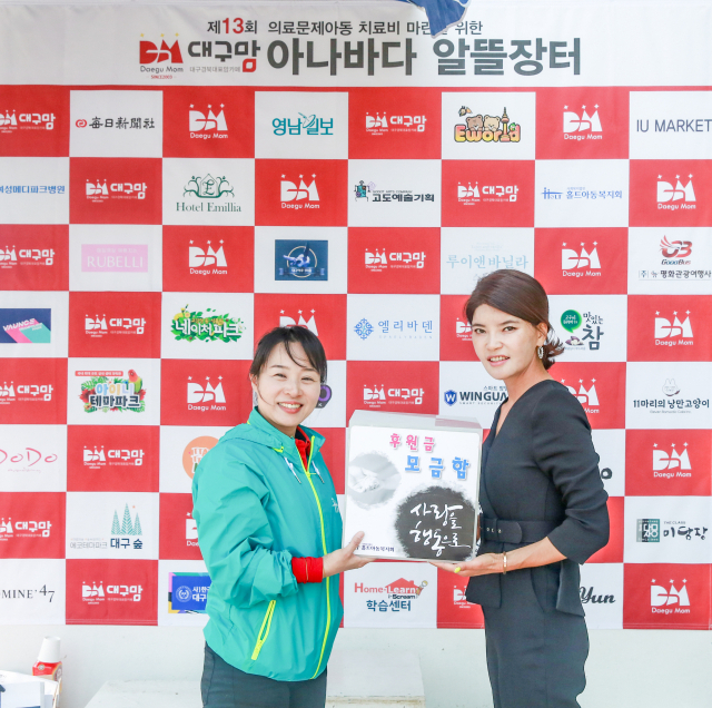 다음카페 대구맘 김지은 대표(오른쪽)가 아나바다 알뜰장터 참가비와 수익금 전액을 대구홀트아동복지회 지윤경 소장(왼쪽)에게 전달했다.