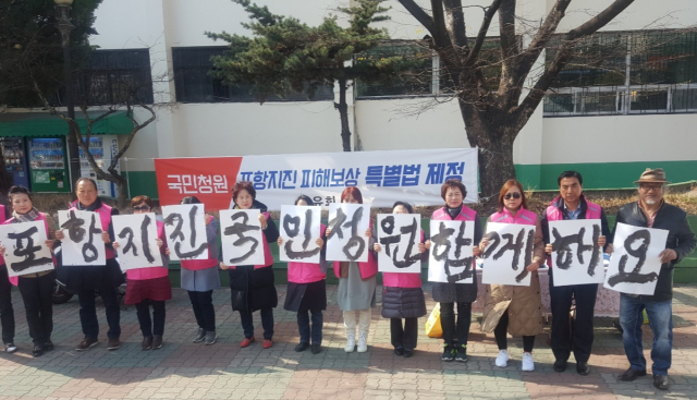 1일 오후 경북 포항시외버스터미널 앞에서 서예가 김동욱씨와 시민들이 포항지진 피해보상 특별법 제정을 촉구하는 서예 퍼포먼스를 하고 있다. 연합뉴스