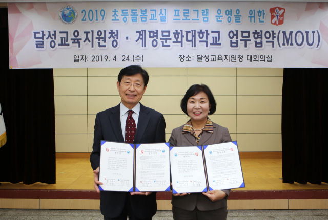 박승호 계명문화대 총장(왼쪽)과 김영옥 대구달성교육지원청 교육장이 24일 초등돌봄교실 운영 업무협약을 체결한 뒤 협약서를 들어보이고 있다. 계명문화대 제공