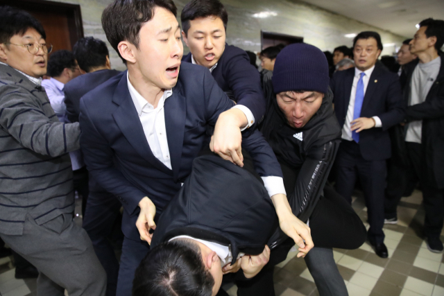 더불어민주당 당직자와 국회 관계자들이 26일 새벽 여야4당의 수사권조정법안을 제출하기 위해 자유한국당 당직자들이 점거하는 국회 의안과 진입을 시도하면서 몸싸움을 벌이고 있다. 연합뉴스