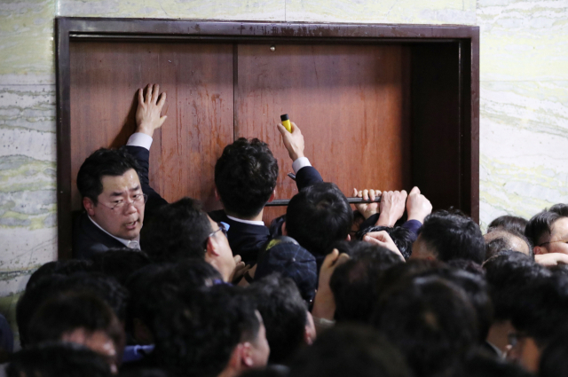 더불어민주당 당직자와 국회 관계자들이 26일 새벽 여야 4당의 수사권조정법안을 제출하기 위해 자유한국당 당직자들이 점거한 국회 의안과 진입을 시도하고 있다. 이 과정에서 