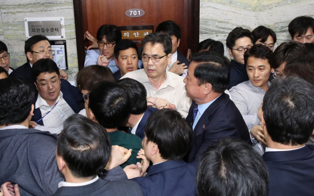 자유한국당 곽상도 의원(가운데)이 26일 새벽 여야4당의 수사권조정법안을 제출하기 위해 국회 의안과에 진입하는 더불어민주당 당직자들을 저지하고 있다. 연합뉴스