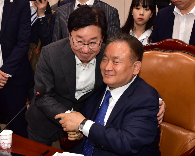 29일 밤 국회 문화체육관광위원회 회의실에서 열린 사법개혁특별위원회에서 공수처·검경수사권 조정안 패스트트랙을 지정한 후 이상민 위원장(오른쪽)과 더불어민주당 박범계 의원이 악수하고 있다. 연합뉴스