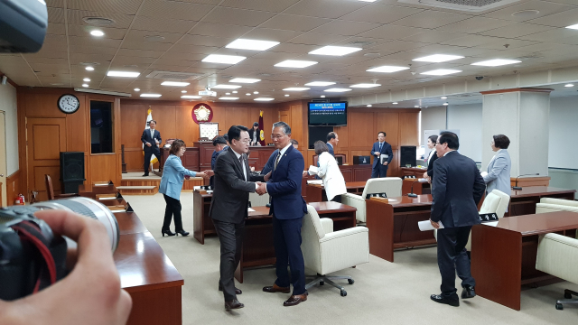홍준연 대구 중구의원(오른쪽)이 1일 중구의회로부터 징계 처분을 받고 회의를 마친 후 오상석 중구의장과 악수하고 있다. 중구의회 제공.