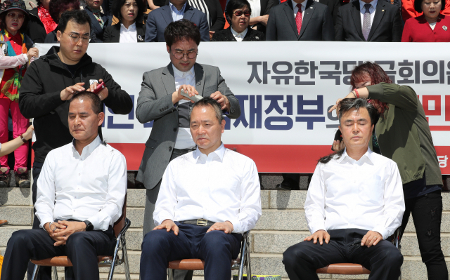 자유한국당 좌파독재저지특별위원장을 맡은 김태흠 의원을 비롯한 4명의 의원과 지역 위원장이 2일 오전 국회 본청 앞에서 선거법 개정안과 고위공직자범죄수사처(공수처) 법안 패스트트랙(신속처리안건) 지정의 부당성을 알리는 삭발식을 하고 있다. 왼쪽부터 이창수 충남도당 위원장, 성일종, 김태흠 의원. 연합뉴스