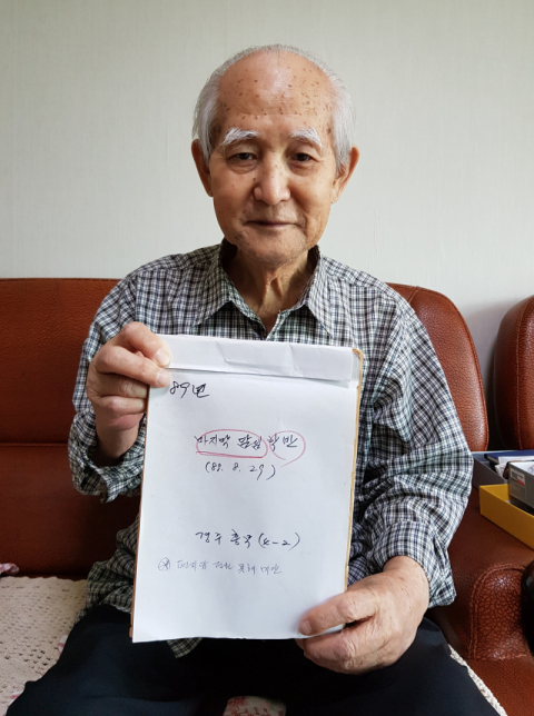 김흥섭 씨가 30년 전 마지막 담임을 지냈던 경주 흥무국민학교 4학년 2반 학생들이 보낸 손편지 묶음집을 들어 보이고 있다. 배형욱 기자