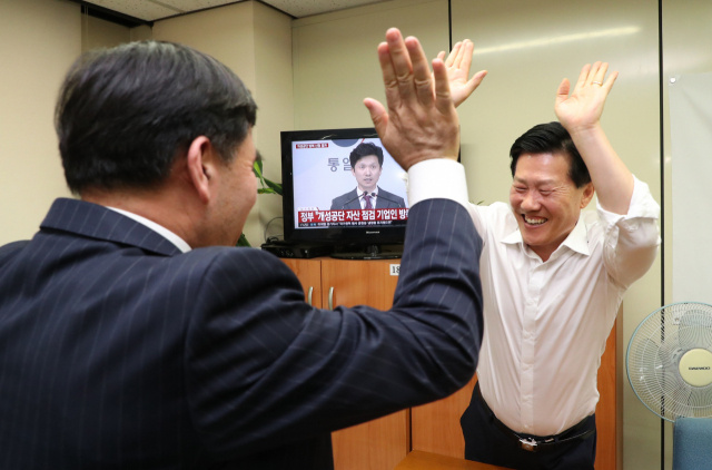 17일 오후 서울 여의도에 있는 개성공단 기업협회에서 유창근 개성공단기업협회 부회장(왼쪽)과 김서진 상무가 개성공단 기업인 방북승인 문제와 관련한 통일부 브리핑을 시청하며 환호하고 있다. 연합뉴스