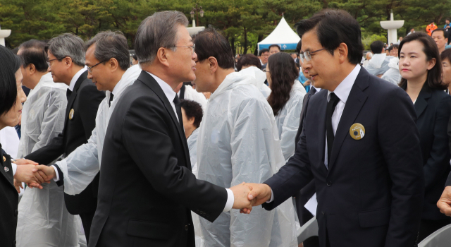 문재인 대통령이 18일 오전 제39주년 5·18 민주화운동 기념식이 열린 광주 국립5·18민주묘지에서 자유한국당 황교안 대표와 인사하고 있다. 연합뉴스