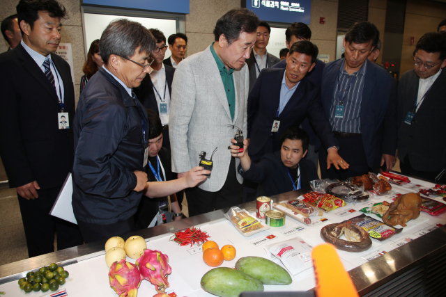 이낙연 국무총리가 주말인 지난 18일 인천공항 입국장 아프리카돼지열병 국경검역장을 방문, 세관에 적발된 반입 금지 농산물과 육가공식품 등을 살펴보고 있다. 연합뉴스