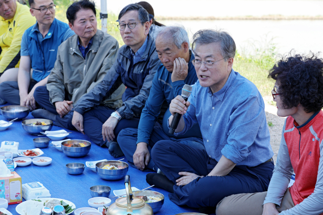 문재인 대통령이 24일 오전 경북 경주시 옥산마을 찾아 모내기를 마친 뒤 주민들과 새참을 함께하며 이야기를 하고 있다.김영진 기자 kyjmaeil@imaeil.com