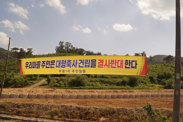 청청마을 경북 구미 무을면에 최근 축사 건립 허가가 잇따르자 주민들이 현수막을 내거는 등 반대하고 있다. 현수막 뒤로 