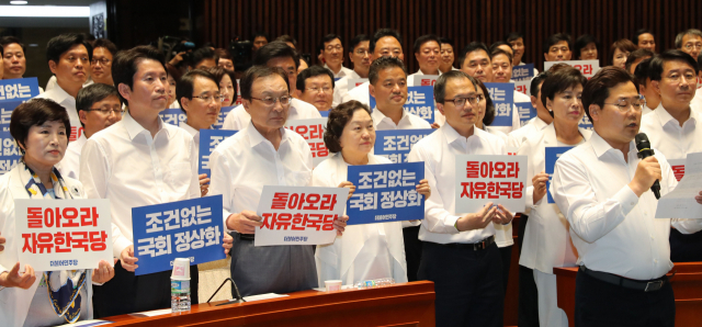 더불어민주당 이해찬 대표와 의원들이 30일 오후 국회 예결위회의장에서 열린 더불어민주당 국회의원 워크숍에서 자유한국당 국회 복귀 촉구 피켓을 들고 있다. 연합뉴스