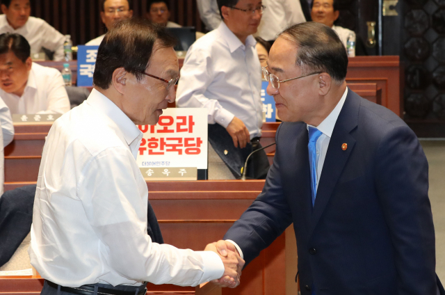 더불어민주당 이해찬 대표(왼쪽)와 홍남기 경제부총리 겸 기획재정부 장관이 30일 오후 국회 예결위회의장에서 열린 더불어민주당 국회의원 워크숍에서 악수하고 있다. 연합뉴스