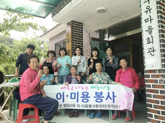 두 약손 이 미용동아리 회원들의 퍼머 커트 등의 봉사활동을 받은 고제면 수유마을 주민들이 기념촬영을 하고 있다.