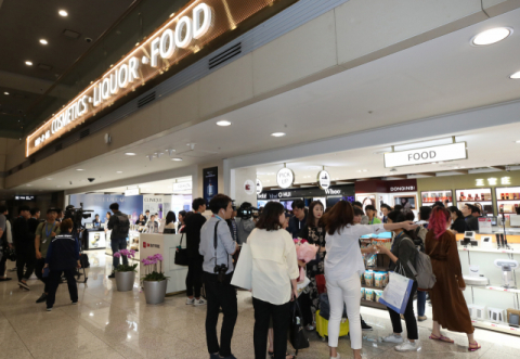 지난달 31일 인천국제공항 1터미널에 문을 연 입국장 면세점에서 여행객들이 물건을 고르고 있다. 연합뉴스