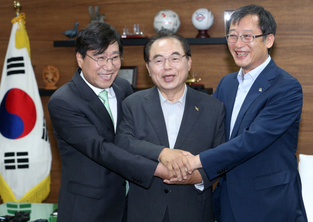 더불어민주당 싱크탱크인 민주연구원 양정철 민주연구원장(왼쪽 첫번째)이 11일 오전 부산시청에서 오거돈 부산시장, 이정호 부산발전연구원장과 함께 손을 맞잡고 있다. 연합뉴스