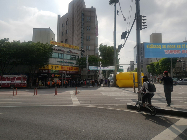 12일 오전 8시30분쯤 대구 남구 영대병원네거리 인근 CCTV 거치대에 한 남성이 올라가 인형을 매달고 시위를 하고 있다. 장성혁 기자.
