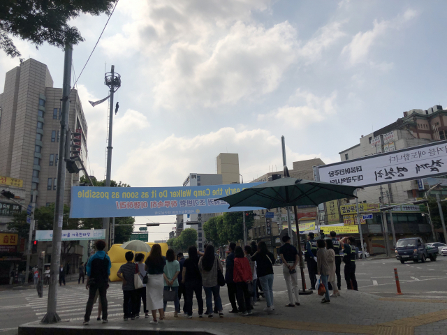 12일 오전 8시30분쯤 대구 남구 영대병원네거리 인근 CCTV 거치대에 한 남성이 올라가 인형을 매달고 시위를 하고 있다. 장성혁 기자.