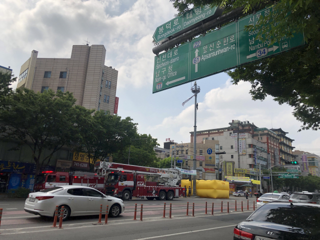 12일 오전 8시30분쯤 대구 남구 영대병원네거리 인근 CCTV 거치대에 한 남성이 올라가 인형을 매달고 시위를 하고 있다. 장성혁 기자.