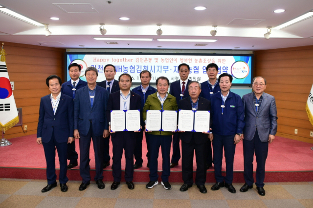 김충섭 김천시장(앞줄 가운데)과 서동완 NH농협김천시지부장(앞줄 왼쪽 세번째) 및 지역농협 조합장들이 11일 Happy together김천운동과 깨끗하고 아름다운 농촌을 만들기 위한 업무협약을 체결하고 기념촬영을하고 있다. 김천시 제공
