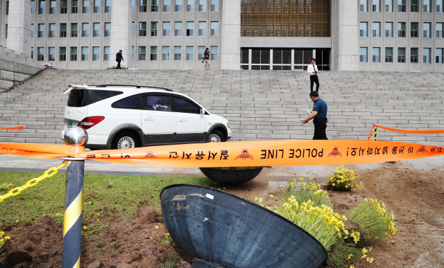 14일 오전 신원미상의 한 남성이 승합차량을 몰고 국회 본청 앞 계단으로 돌진, 경찰 관계자들이 사고 수습을 하고 있다 연합뉴스