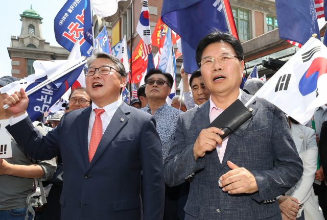 자유한국당 홍문종(오른쪽) 의원이 15일 오후 서울역 광장에서 열린 태극기집회에 참석, 조원진 대한애국당 대표와 구호를 외치고 있다. 이 자리에서 탈당 선언을 한 홍문종 의원은 대한애국당 공동대표로 추대됐다. 연합뉴스