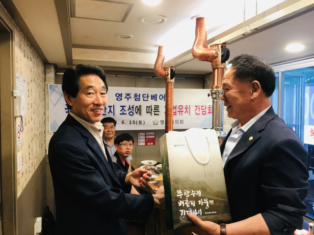 이중호(오른쪽) 영주시의회 의장이 출향 기업인에게 영주 첨단베어링국가산단 조성 홍보물을 전달하고 있다. 영주시 제공