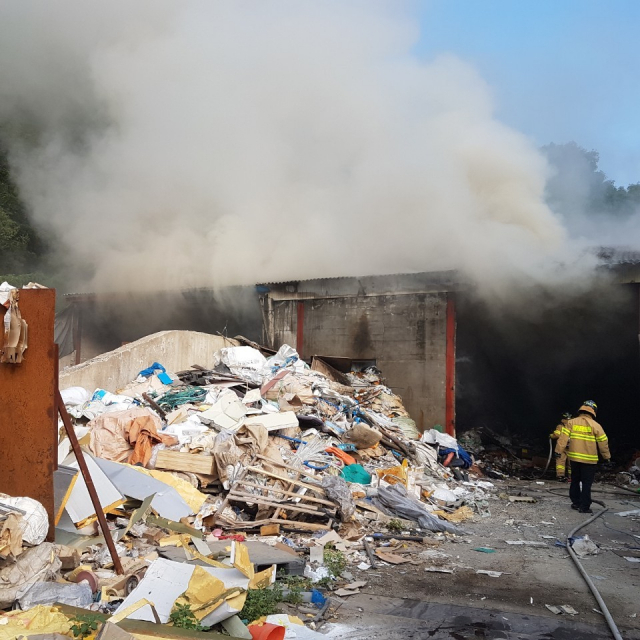 21일 오전 7시 4분쯤 대구 달성군 논공읍 노이리 한 폐기물 처리 공장에서 불이 난 가운데 처리장 바깥으로 쌓여있는 폐기물 더미가 보인다. 대구 달성소방서 제공