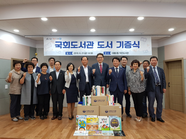 국회도서관이 21일 대구 중구 대봉2동 작은도서관에서 허용범 국회 도서관장(오른쪽에서 5번째)과 중구청 관계자들이 참석한 가운데 도서기증식을 진행했다. 중구청 제공.