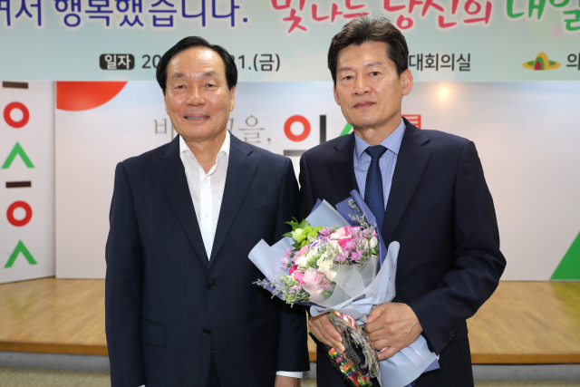 김용우(오른쪽) 의성군 관광경제국장이 김주수 의성군수로부터 퇴임 공로패를 받고 기념촬영을 하고 있다. 의성군 제공