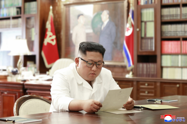 김정은 북한 국무위원장이 집무실로 보이는 공간에서 도널드 트럼프 미 대통령의 친서를 읽고 있는 모습을 조선중앙통신이 23일 보도했다. 연합뉴스