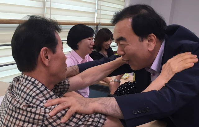 김태원 대구시의원(오른쪽)이 한 강연장에서 청중의 어깨에 손을 올리고 눈을 맞추며 기분이 좋아지는 단어를 반복하는 동작을 하고 있다.