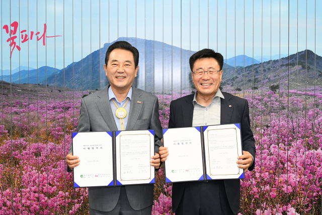 김문오 달성군수(왼쪽)과 김경호 한국전력공사 동대구지사가 업무협약 체결 후 기념촬영을 하고 있다. 달성군 제공