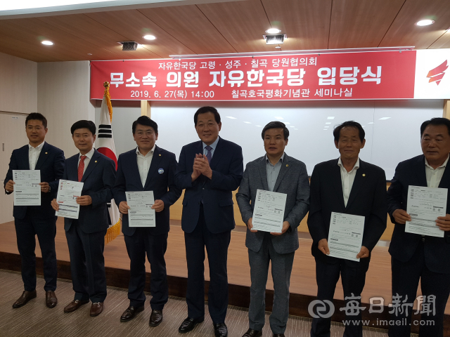 성주·고령군 출신 무소속 광역·기초의원 7명 서명한 한국당 입당원서를 들어 보이고 있다. (왼쪽부터 도희재·성원환·구교강 군의원, 김항곤 당협위원장, 정영길 도의원, 김영래·김경호 군의원) 이영욱 기자