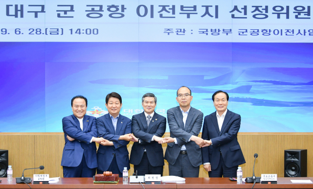 28일 열린 대구경북 통합신공항 이전부지 선정위원회 위원들이 손을 맞잡고 연내 최종 이전지 선정을 약속했다. 왼쪽부터 김영만 군위군수, 권영진 대구시장, 정경두 국방부장관, 윤종진 경북도 행정부지사, 김주수 의성군수. 대구시 제공