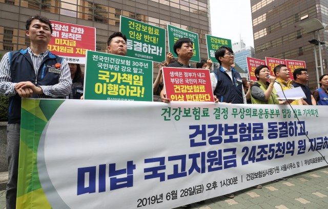 무상의료운동본부 관계자들이 28일 건강보험정책심의위원회가 열린 서울 서초구 건강보험심사평가원 앞에서 건강보험료 동결과 미납 국고지원금 지급 등을 촉구하는 기자회견을 하고 있다. 연합뉴스