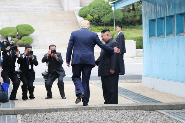 도널드 트럼프 미국 대통령이 30일 오후 판문점에서 김정은 북한 국무위원장과 만나 인사한 뒤 군사분계선을 넘어 북측으로 향하고 있다. 연합뉴스