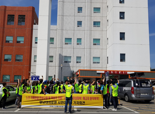 영남대의료원 범시민대책위 회원들이 응급의료센터 옥상에서 농성 중인 해고자들에게 손을 흔들고 있다. 채원영 기자.