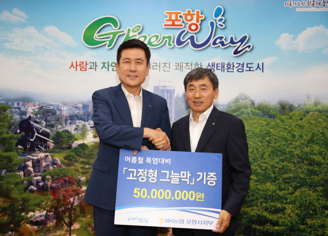 이강덕(왼쪽) 포항시장과 김춘안 NH농협 포항시지부 지부장이 악수를 나누며 기념촬영을 하고 있다. NH농협 포항시지부 제공