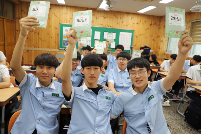 대구 경상고등학교 학생들은 매일 감사 일기를 쓴다. 친구, 교사, 가족 등 주위 사람들에게 감사하는 마음을 글로 남긴다. 그러면서 학생들의 마음가짐도 달라지고 있다. 감사 일기를 손에 든 경상고 학생들 모습. 경상고 제공
