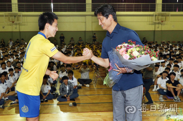 U-20 남자축구 월드컵대회 준우승을 이끈 정정용 감독이 12일 모교인 대구 청구고등학교를 방문, 재학생으로부터 환영 꽃다발을 받은 뒤 인사를 나누고 있다. 성일권 기자 sungig@imaeil.com