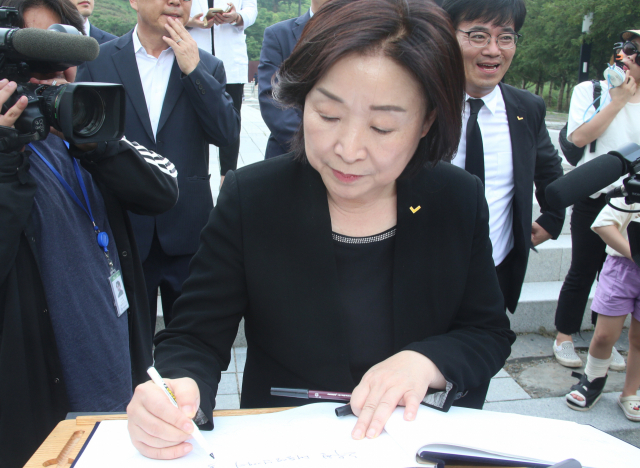 정의당 심상정 신임 대표가 14일 오후 경남 김해시 진영읍 봉하마을 노무현 전 대통령 묘역에 참배한 뒤 방명록을 쓰고 있다. 연합뉴스