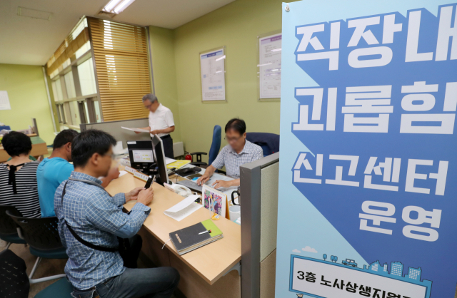직장 내 괴롭힘 금지법 시행 첫 날인 16일 경기도 수원시 고용노동부 경기지청 민원실에 마련된 직장 내 괴롭힘 신고센터에서 민원인들이 상담을 하고 있다. 연합뉴스