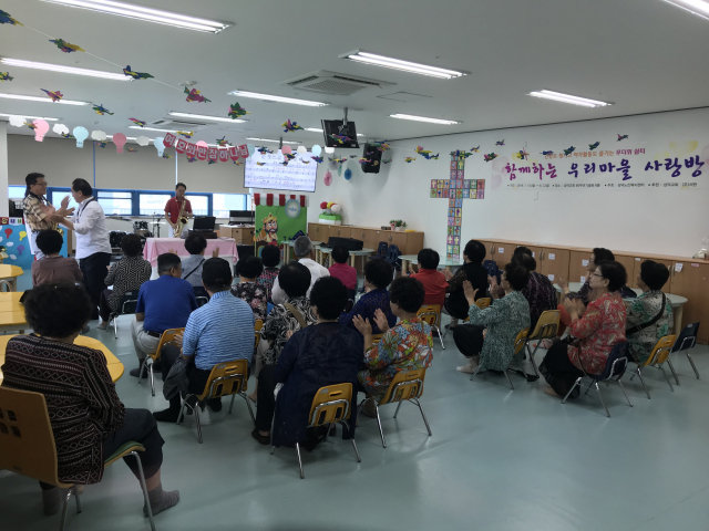 지난 15일 삼덕교회 60주년 기념관에 마련된 무더위 쉼터에서 대경상록자원봉사단이 홀몸노인들을 상대로 색소폰 공연을 하고 있다. 중구재가노인지역협의체 제공