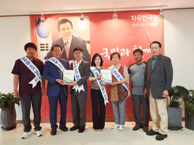 영주댐 조기담수추진위원회 위원들이 21일 최교일 의원에게 서명지를 전달하고 있다. 마경대 기자