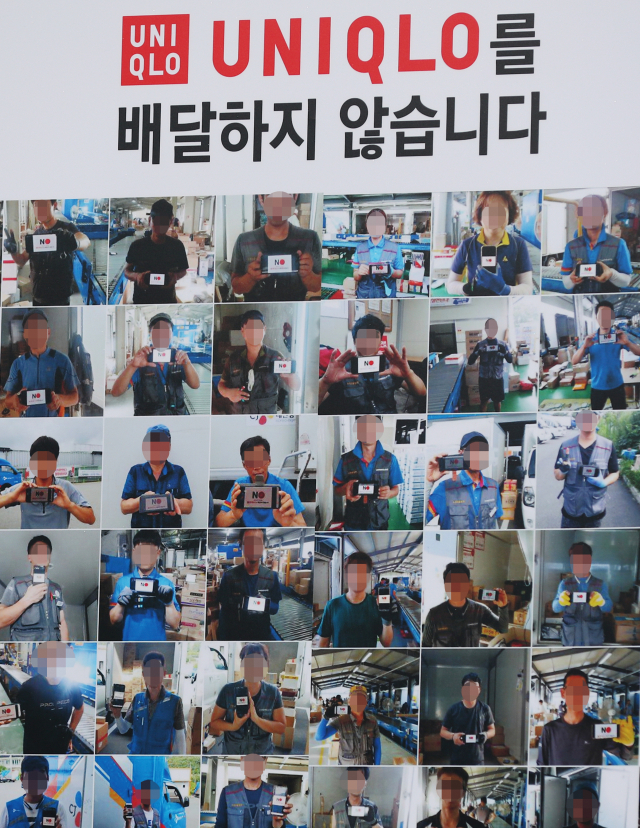 24일 오전 서울 종로구 옛 일본대사관 앞에서 열린 택배노조의 유니클로 제품 배송 거부 기자회견에 설치된 배너에 배송거부 스티커를 든 택배노동자의 모습이 인쇄되어 있다. 연합뉴스