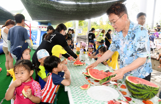 지난주 경북도 청사 다목적구장에 개장한 간이 물놀이장에서 이철우 경북도지사가 물놀이를 온 아이들에게 수박을 나눠주고 있다. 경북도 제공