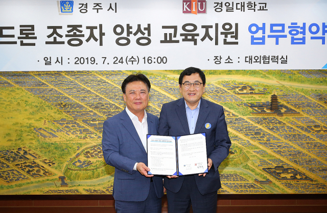 최근 경주시청에서 정현태 경일대학교 총장(왼쪽)과 주낙영 경주시장이 드론 조종사 양성 교육지원 업무협약을 체결한 뒤 협약서를 들어보이고 있다. 경일대 제공
