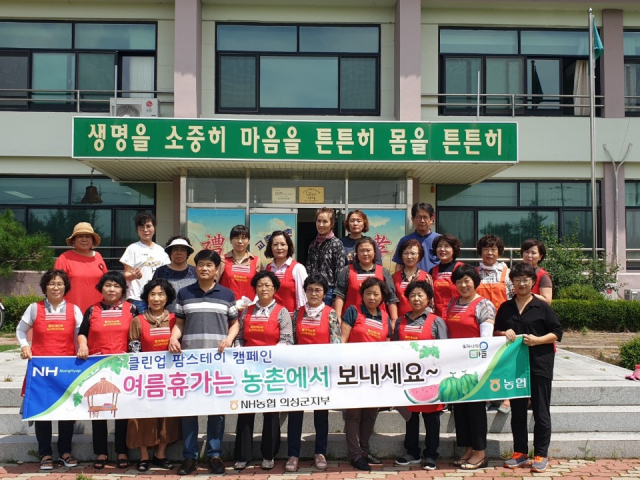 농협중앙화 의성군지부·안계농협 농가주부모임 회원들이 안계면 교촌리 팜스테이 교촌마을에서 환경 정화 활동과 함께 여름 휴가 캠페인을 펼친 뒤 기념촬영을 하고 있다. 농협중앙회 의성군지부 제공